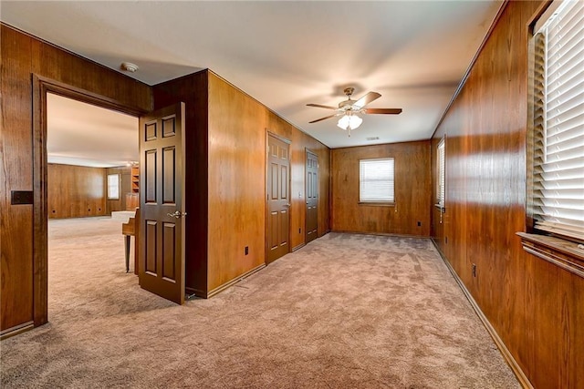 interior space featuring wooden walls and light carpet