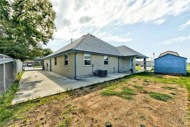 rear view of property with a patio area, a storage unit, and central air condition unit