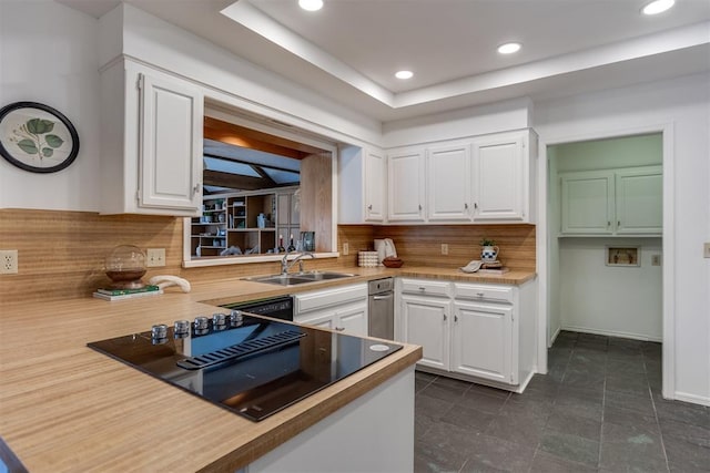 kitchen featuring tasteful backsplash, white cabinetry, sink, and black appliances