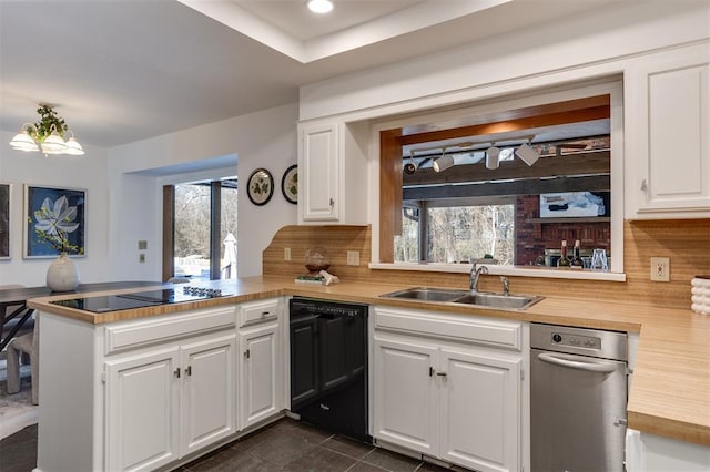 kitchen with sink, white cabinetry, plenty of natural light, black appliances, and kitchen peninsula