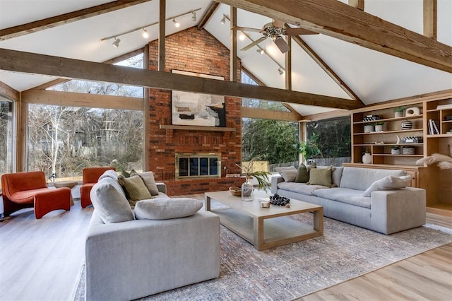 living room with expansive windows, vaulted ceiling with beams, hardwood / wood-style flooring, ceiling fan, and a fireplace