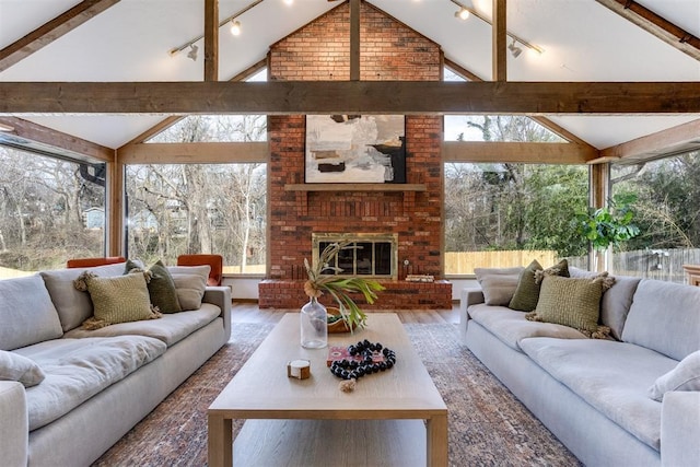 living room featuring a brick fireplace, vaulted ceiling with beams, hardwood / wood-style floors, and a wall of windows