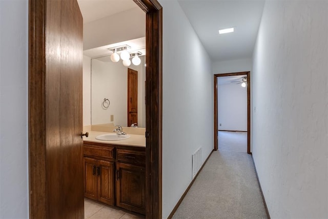 corridor featuring light colored carpet and sink