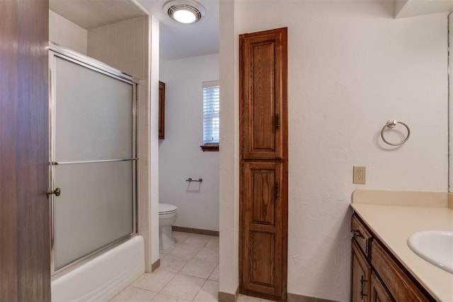 full bathroom featuring vanity, tile patterned flooring, enclosed tub / shower combo, and toilet