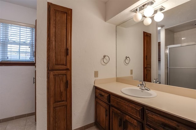 bathroom featuring tile patterned flooring, vanity, and walk in shower