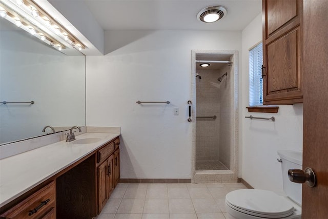 bathroom featuring vanity, tiled shower, tile patterned floors, and toilet