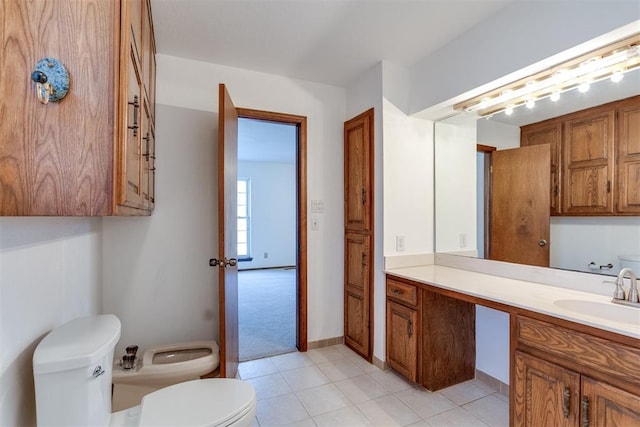 bathroom with a bidet, vanity, tile patterned floors, and toilet