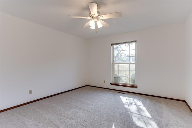 carpeted spare room featuring ceiling fan