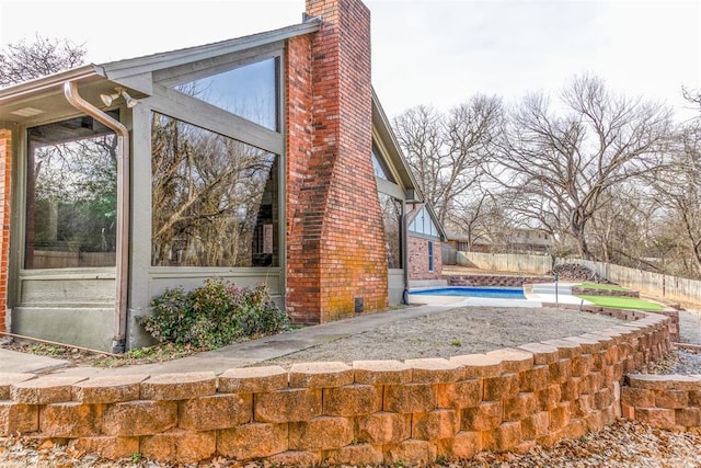 view of property exterior with a fenced in pool