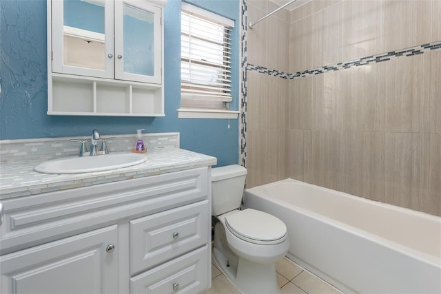 full bathroom with tiled shower / bath combo, toilet, tile patterned floors, and vanity