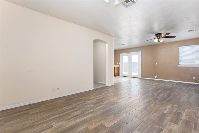 empty room with dark hardwood / wood-style flooring, ceiling fan, and french doors