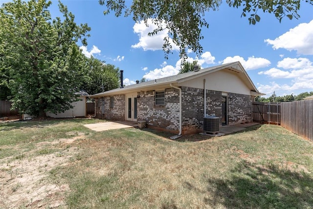 exterior space featuring central air condition unit, a shed, a lawn, and a patio area