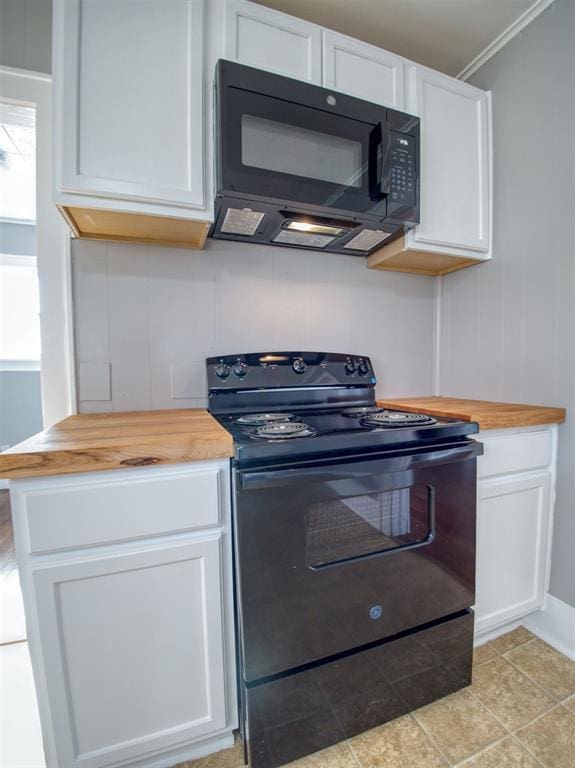 kitchen featuring black appliances, white cabinetry, butcher block countertops, and ornamental molding