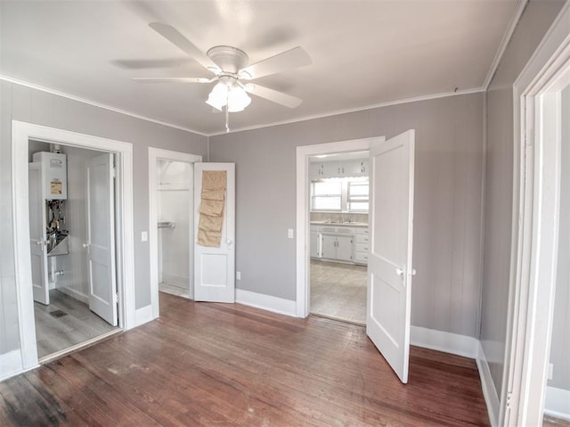 unfurnished bedroom with ceiling fan, connected bathroom, crown molding, and water heater