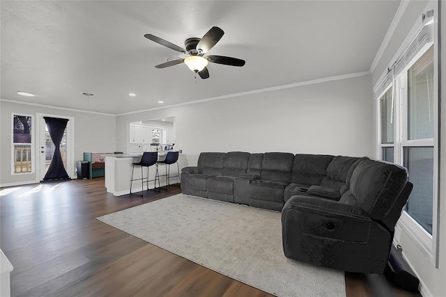 living room with crown molding, ceiling fan, and dark hardwood / wood-style flooring