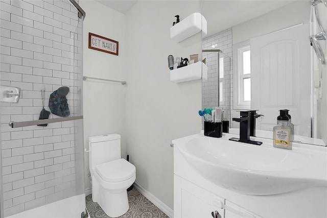 bathroom featuring vanity, toilet, and a shower with shower door