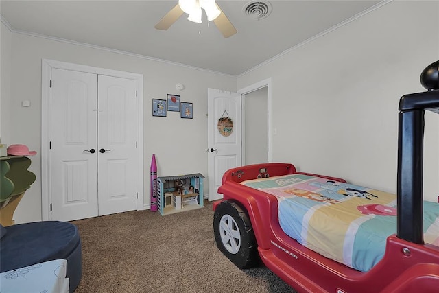 carpeted bedroom with crown molding, ceiling fan, and a closet