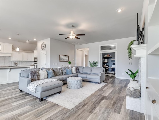 living room featuring light hardwood / wood-style flooring and ceiling fan