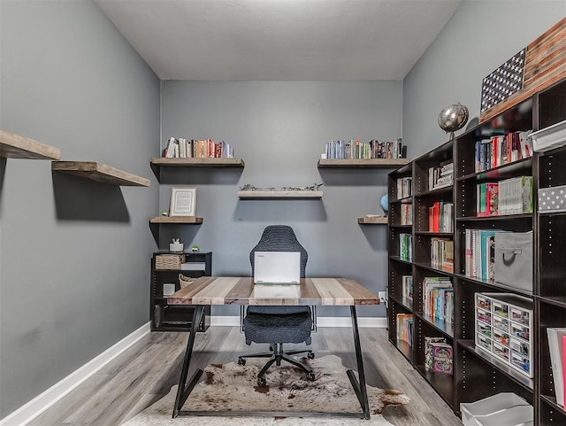 home office with light hardwood / wood-style flooring