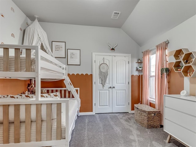 carpeted bedroom with vaulted ceiling and a closet