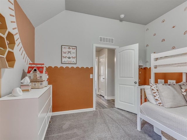 carpeted bedroom with lofted ceiling