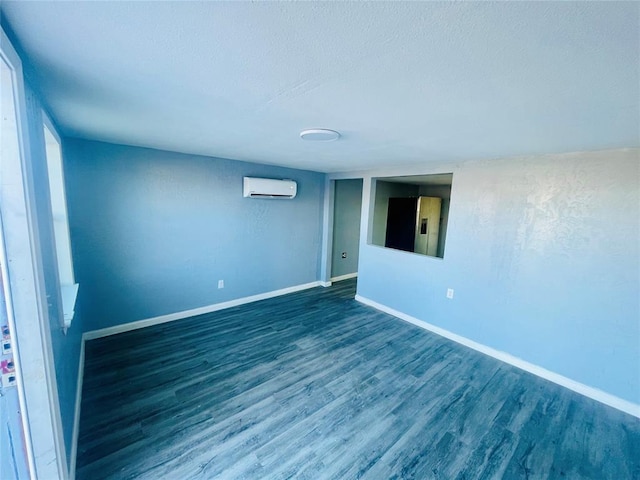 unfurnished room featuring an AC wall unit and dark wood-type flooring