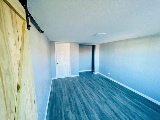 interior space with a textured ceiling and dark hardwood / wood-style floors