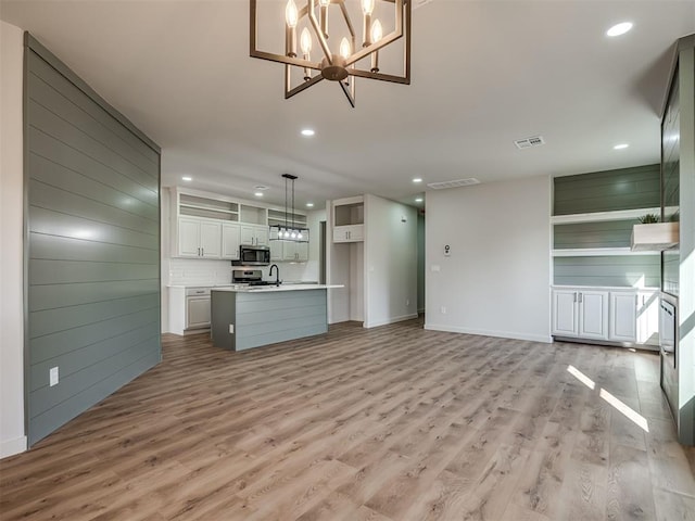 unfurnished living room featuring sink and light hardwood / wood-style floors