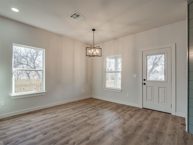 unfurnished dining area featuring recessed lighting, a notable chandelier, visible vents, baseboards, and light wood-style floors