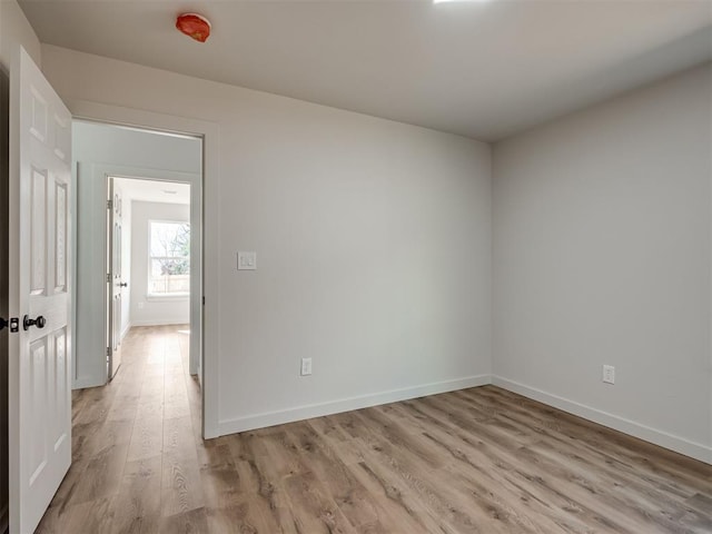 unfurnished room featuring light wood-type flooring and baseboards