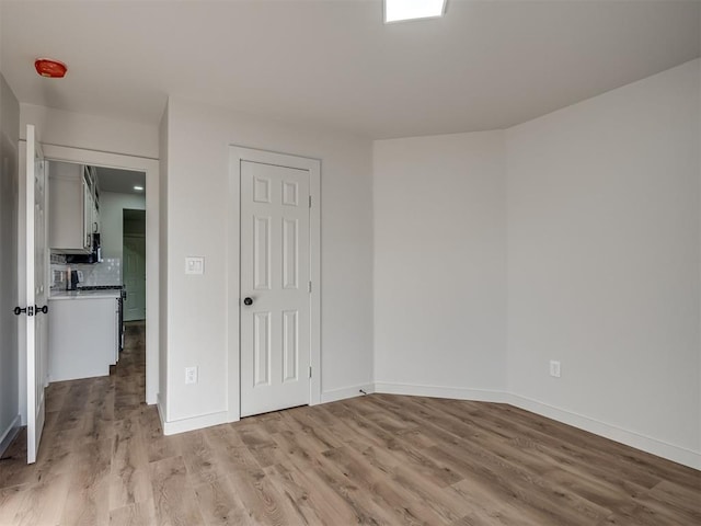 unfurnished bedroom with a closet and light wood-type flooring