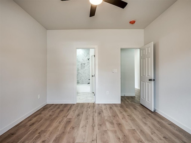 unfurnished bedroom with a ceiling fan, connected bathroom, light wood-style flooring, and baseboards