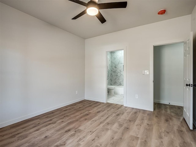 unfurnished bedroom featuring connected bathroom, ceiling fan, and light hardwood / wood-style flooring