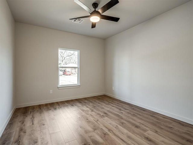 unfurnished room with light wood-style floors, visible vents, baseboards, and a ceiling fan