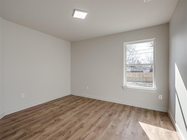 empty room featuring a healthy amount of sunlight and light hardwood / wood-style floors