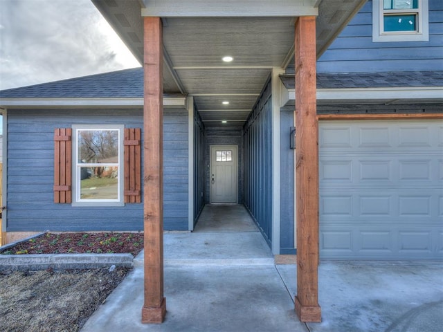 view of exterior entry featuring a shingled roof