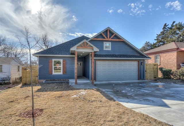 view of front of house featuring a garage, concrete driveway, roof with shingles, and fence