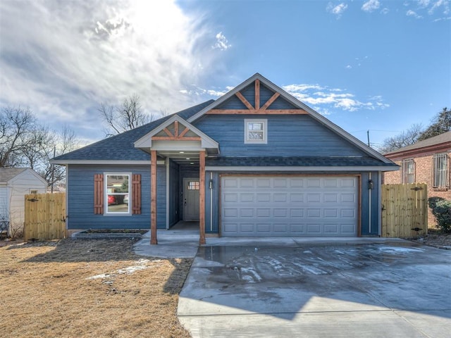 view of front of property with concrete driveway, a shingled roof, and fence