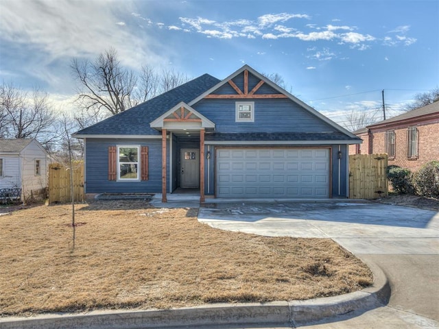 view of front of house featuring concrete driveway, roof with shingles, fence, and an attached garage