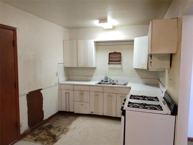 kitchen with sink, backsplash, and white gas range oven