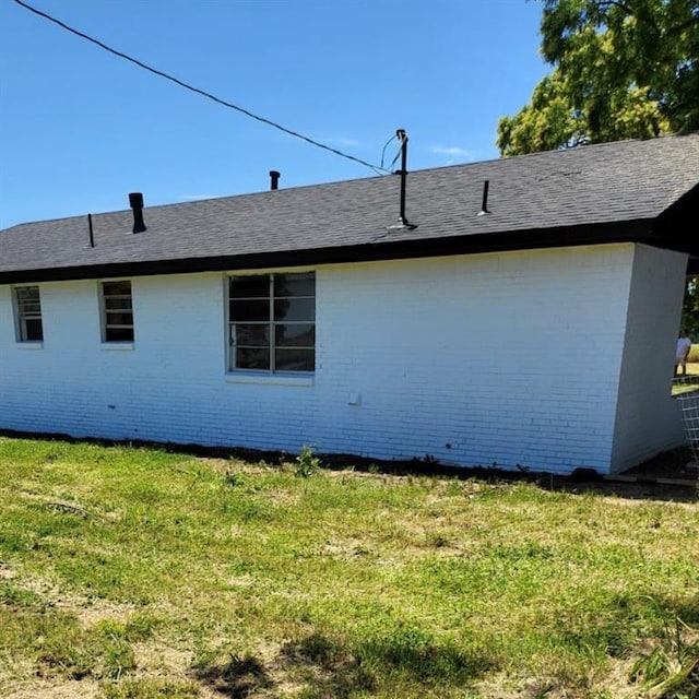 view of side of home with a lawn