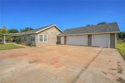 ranch-style house with a garage and cooling unit