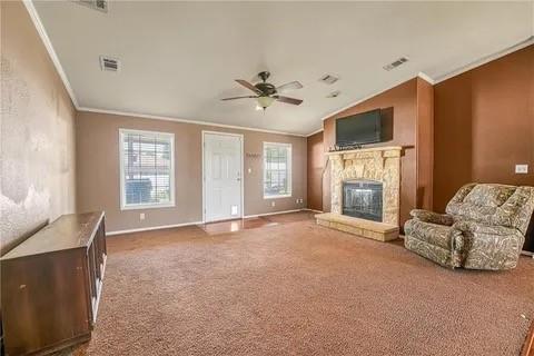 unfurnished living room featuring a wealth of natural light, crown molding, lofted ceiling, and a fireplace