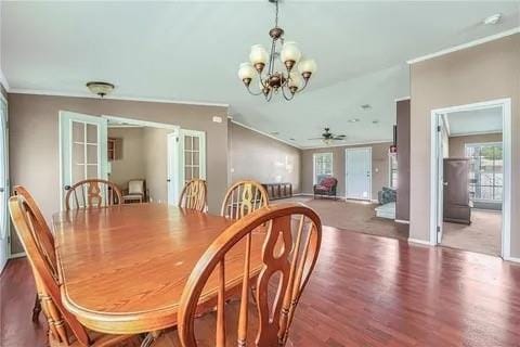 dining area with ceiling fan with notable chandelier, dark wood-type flooring, a wealth of natural light, and ornamental molding