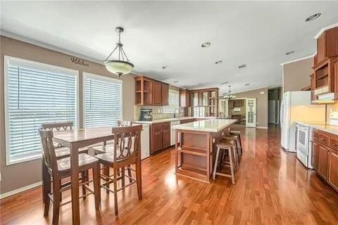 kitchen with decorative light fixtures, plenty of natural light, hardwood / wood-style flooring, and white range