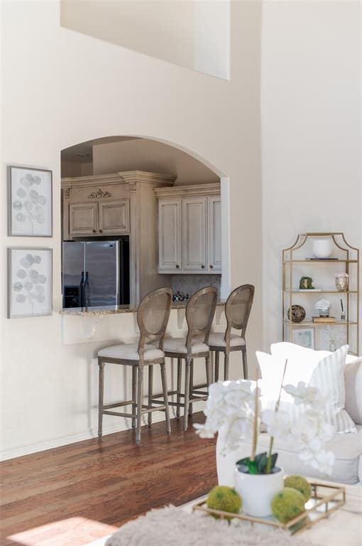 kitchen featuring stainless steel refrigerator with ice dispenser, backsplash, dark hardwood / wood-style flooring, and cream cabinetry