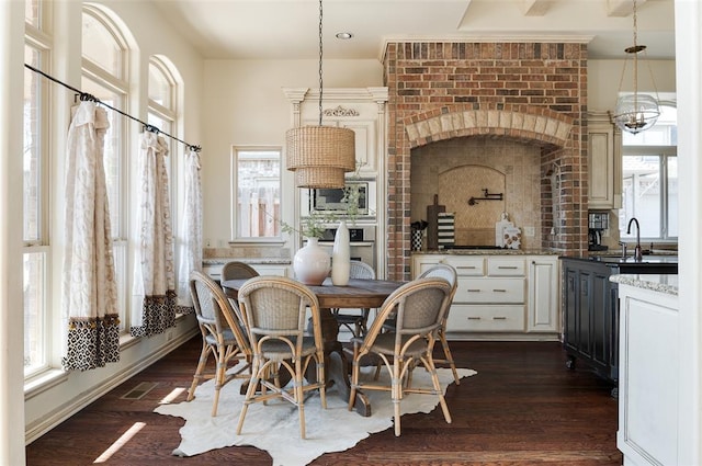 dining room featuring plenty of natural light, dark hardwood / wood-style floors, and sink