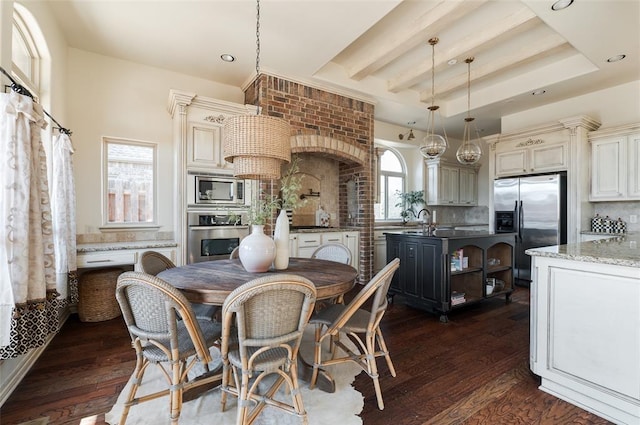 dining space with a tray ceiling, dark hardwood / wood-style flooring, and sink