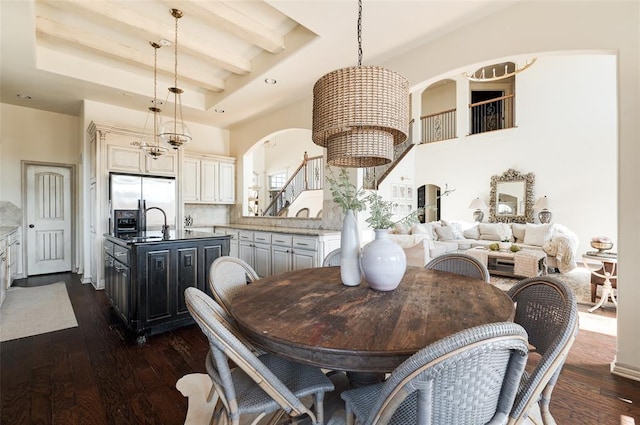 dining area featuring beam ceiling, dark hardwood / wood-style floors, and a chandelier