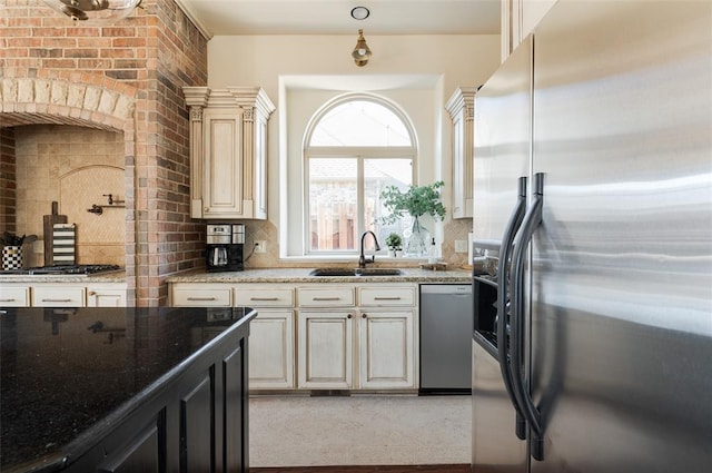 kitchen with appliances with stainless steel finishes, light stone countertops, sink, and decorative backsplash